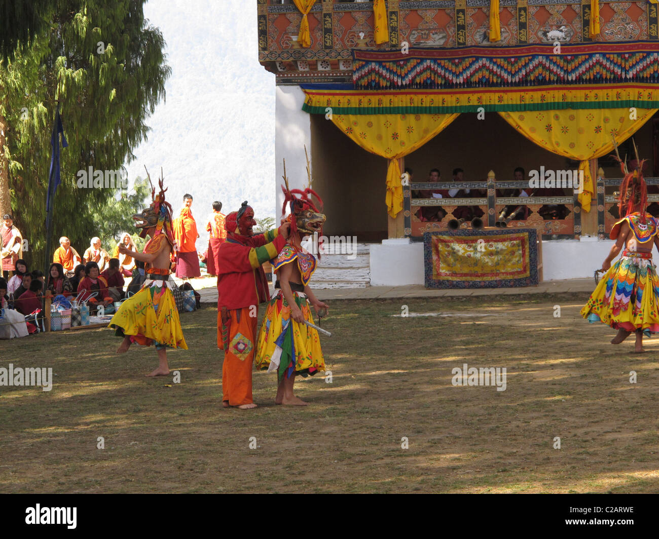 Clown helping with the mask of a dancer, Talo Festival, Bhutan Stock Photo