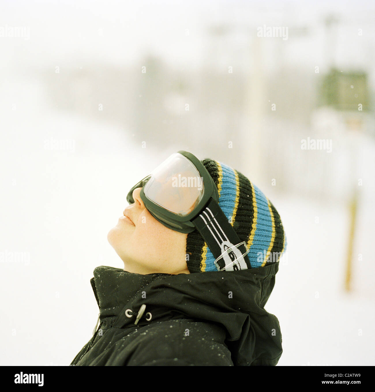 Woman wearing ski goggles looking up Stock Photo Alamy