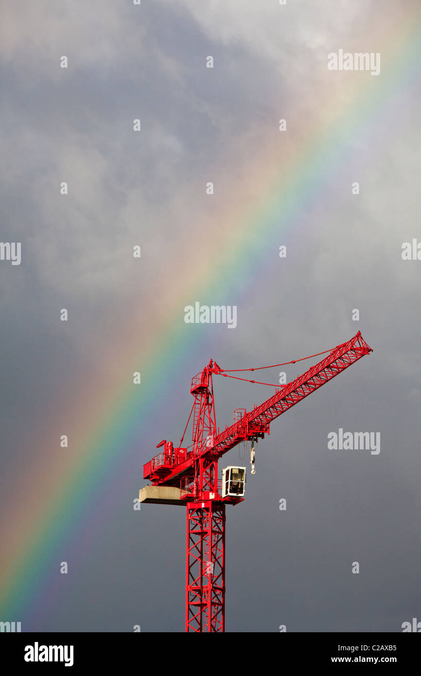 Tower crane with a rainbow overhead Stock Photo