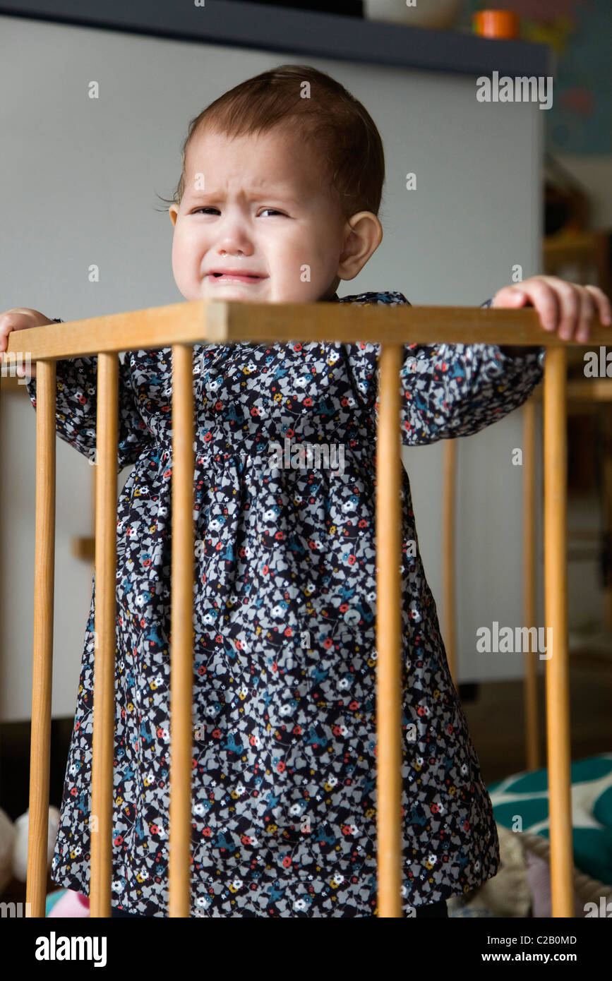 Baby girl crying in crib Stock Photo Alamy