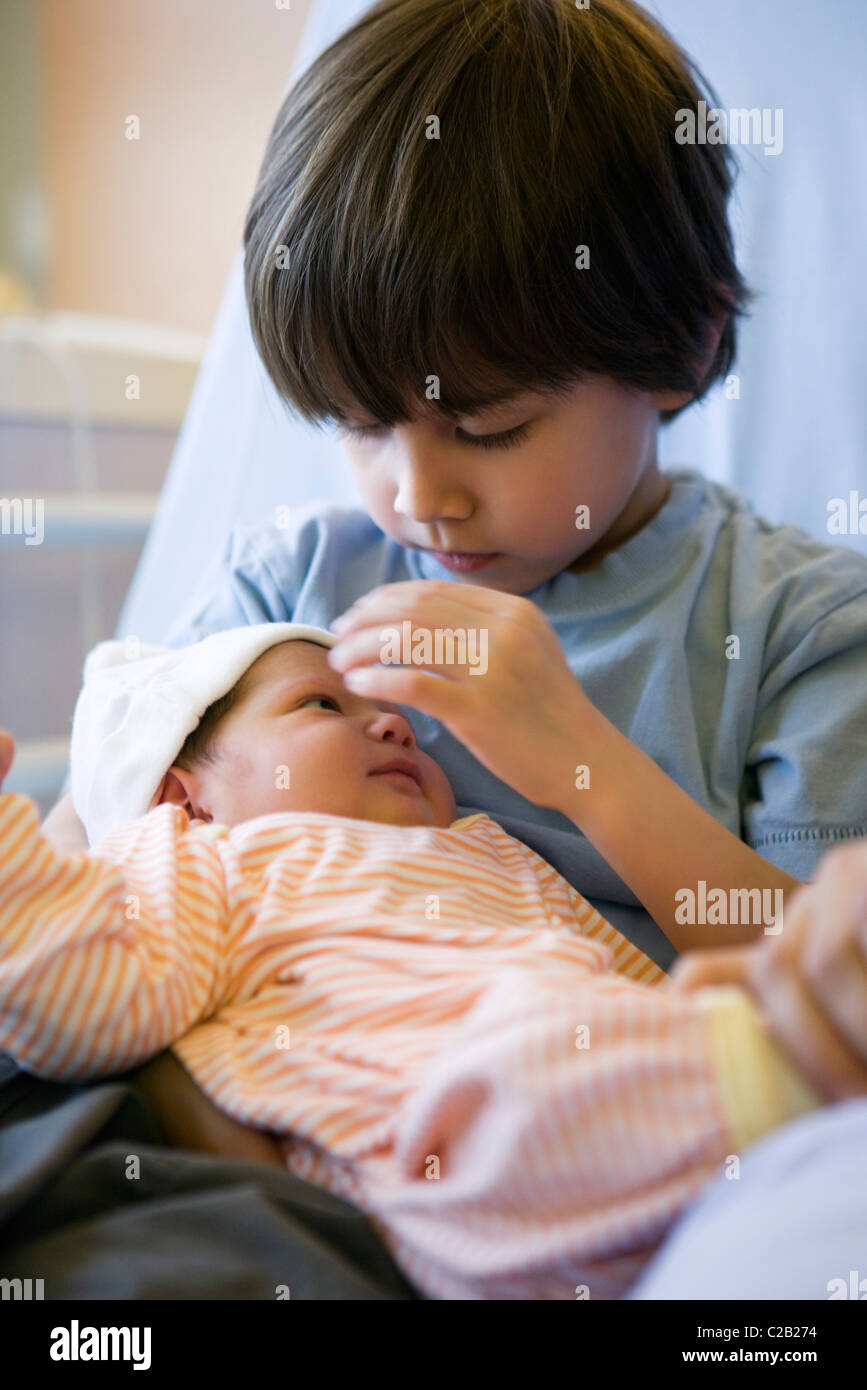 Young boy holding baby sibling Stock Photo Alamy