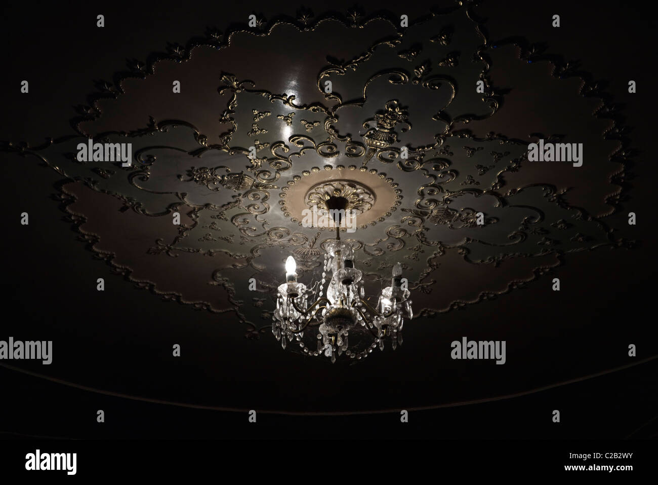 Crystal chandelier lit up in darkness Stock Photo
