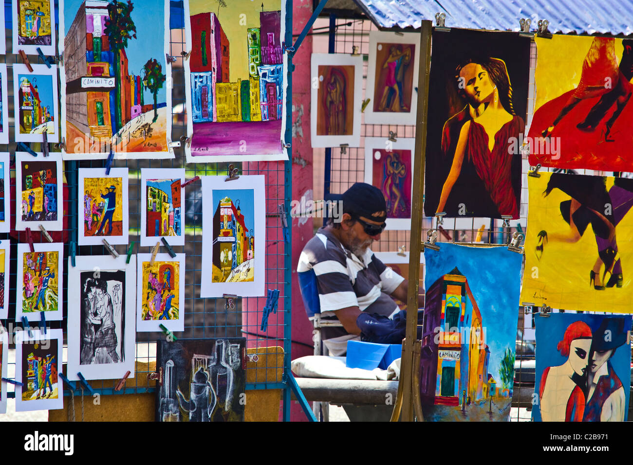 A market stall displays colorful paintings featuring Tango dancers. Stock Photo
