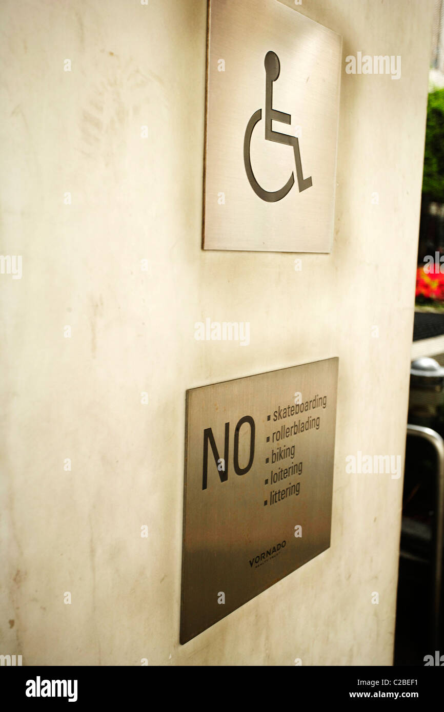 Wheelchair access sign and NO skateboarding rollerblading biking loitering or littering sign Stock Photo