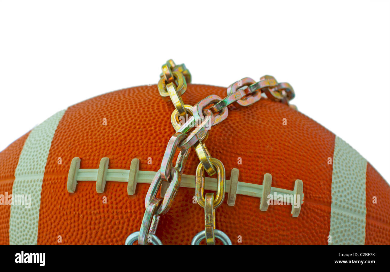 A football tied with iron chains, concept for lockout Stock Photo Alamy
