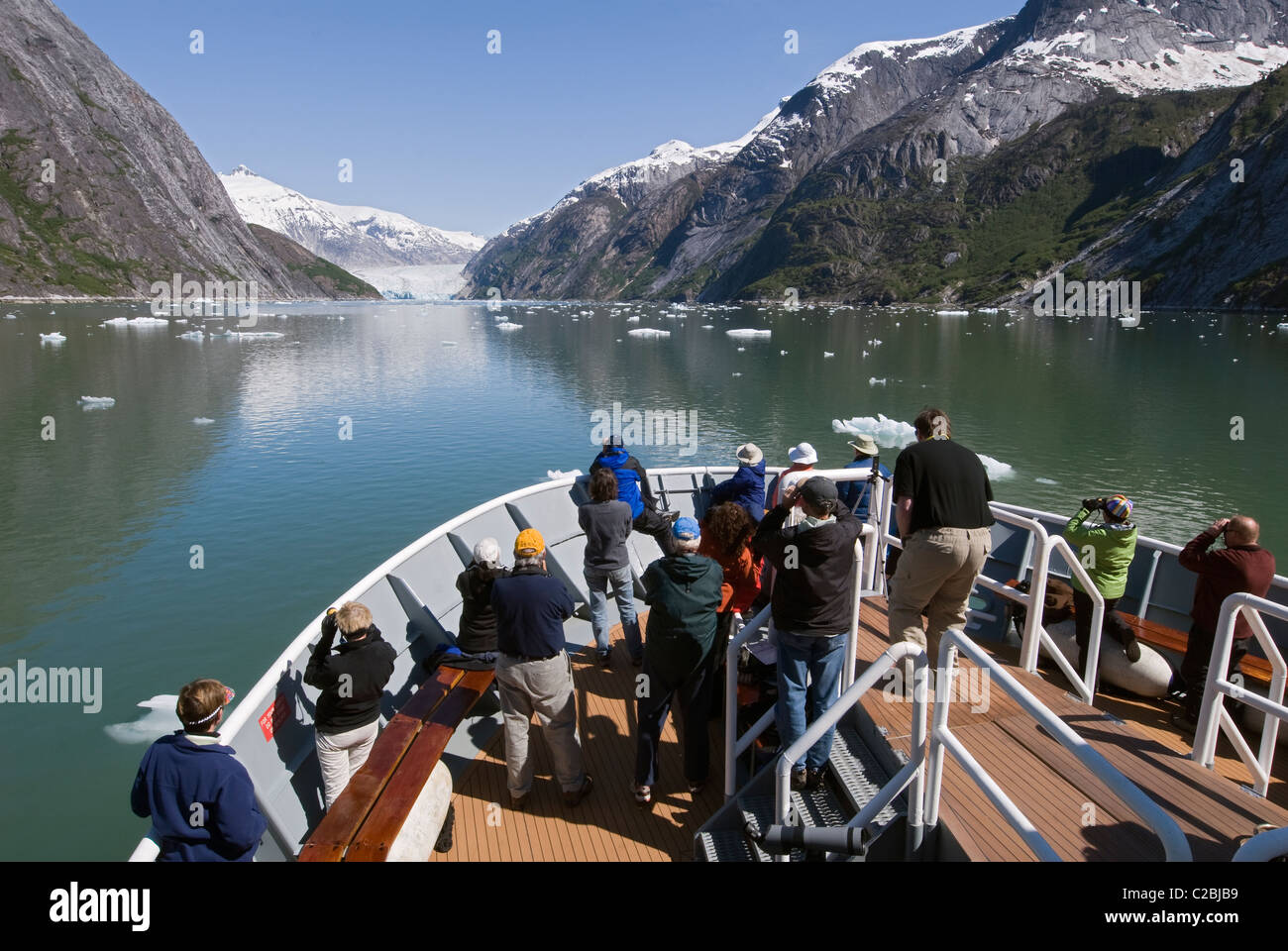 Ecotourists in the bow of the National Geographic Sea Bird in Endicott Arm. Stock Photo