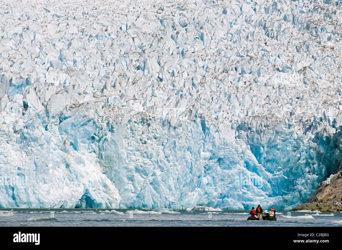 Ecotourists in a zodiac in front of Dawes Glacier. Stock Photo
