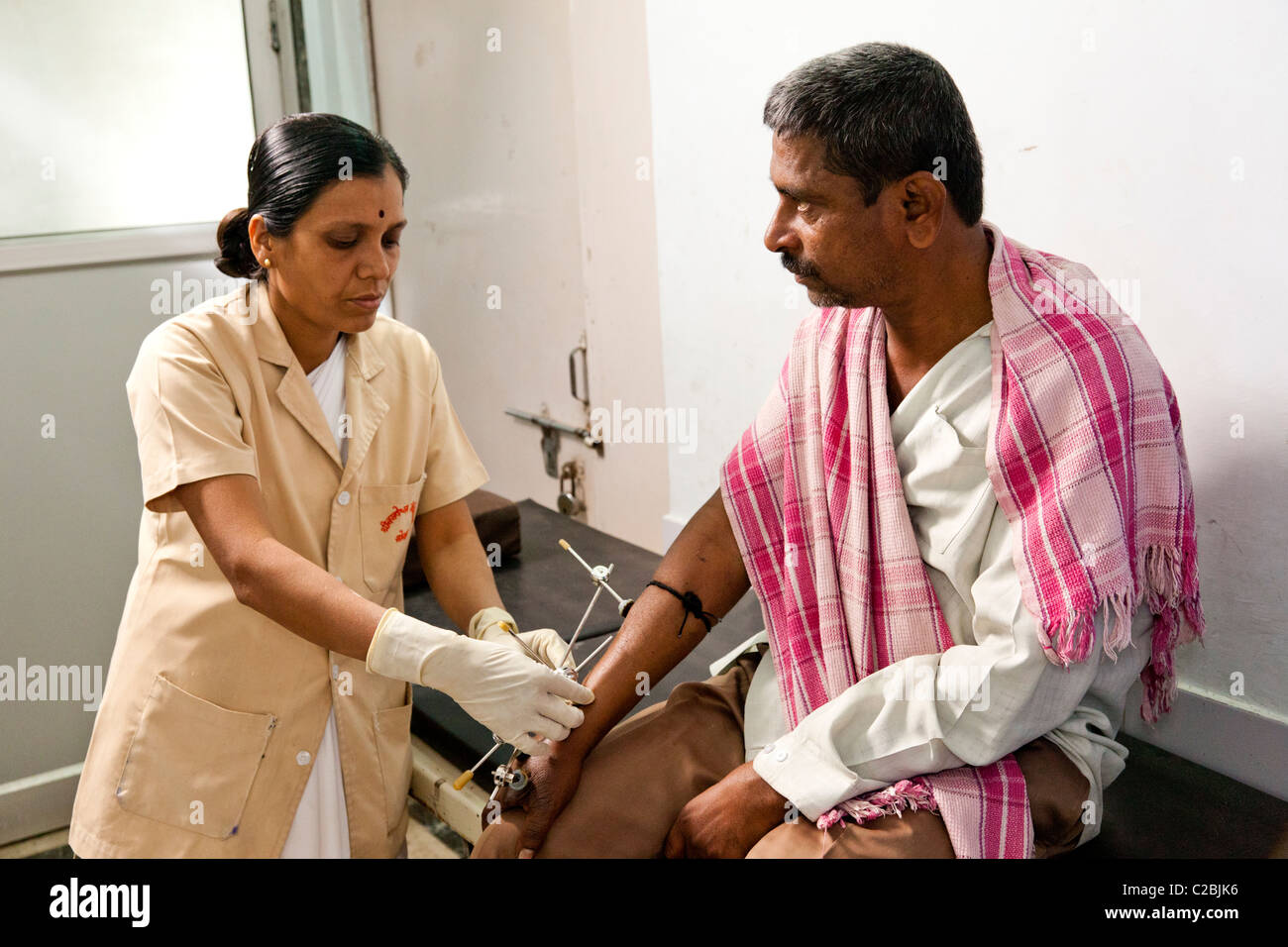 A nurse treats an amputee patient with an external fixator at Basveshwar Hospital Sholapur India Stock Photo