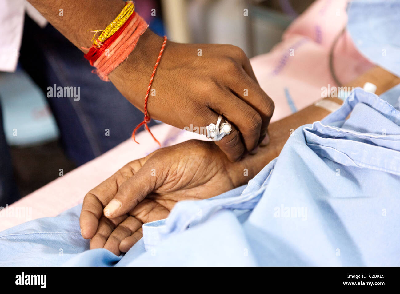 Indian male nurse checking a patients pulse at Yashodhara Hospital Sholapur India Stock Photo