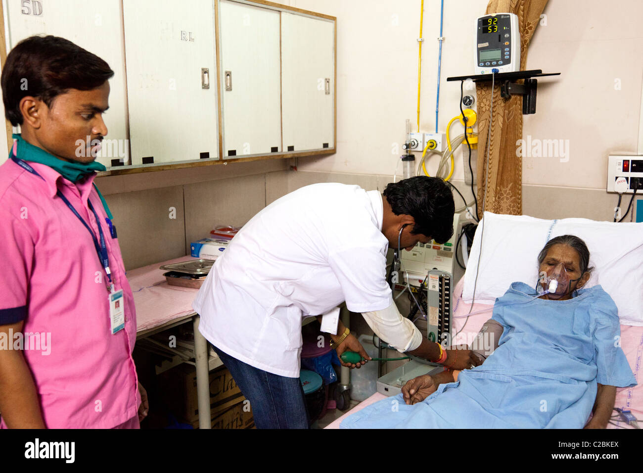 An Indian male nurse checks the blood pressure of a female patient at Yashodhara Hospital Sholapur India Stock Photo