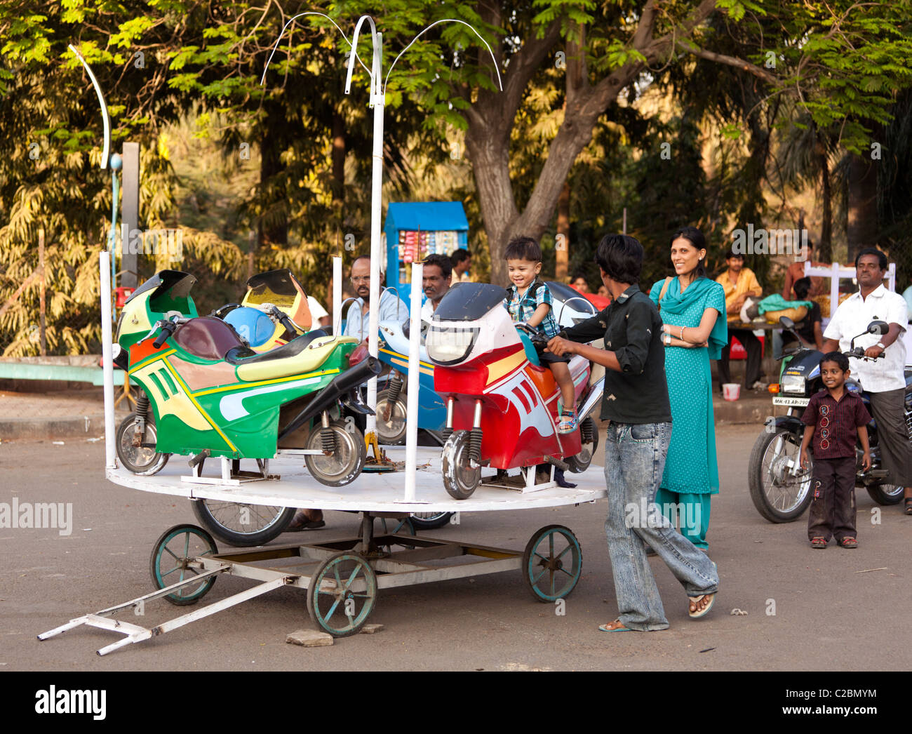 A young Indian boy being pushed on a merry go round in Sholapur Maharashtra India Stock Photo