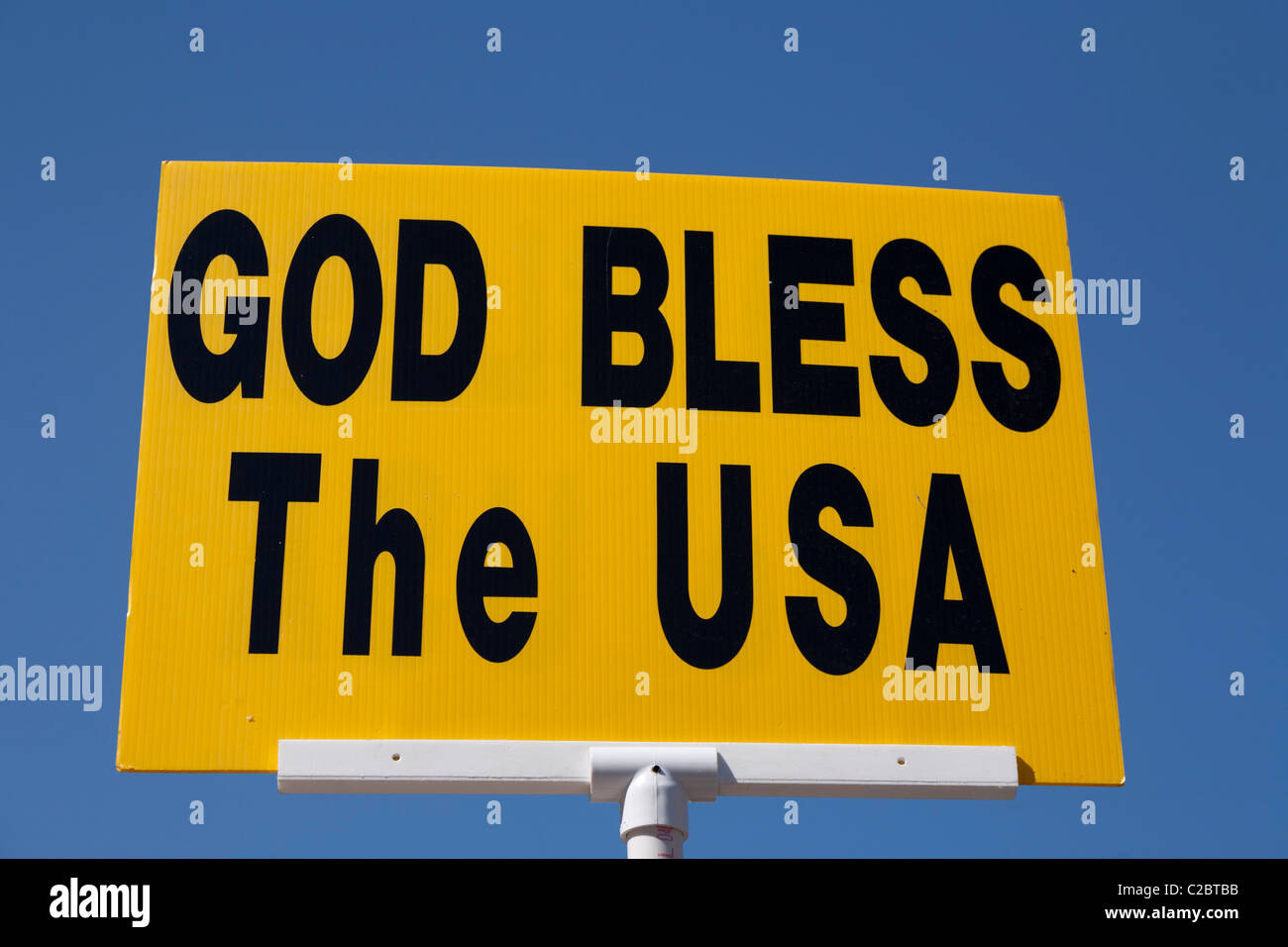 God Bless the USA sign on a yellow background against a blue sky. Stock Photo