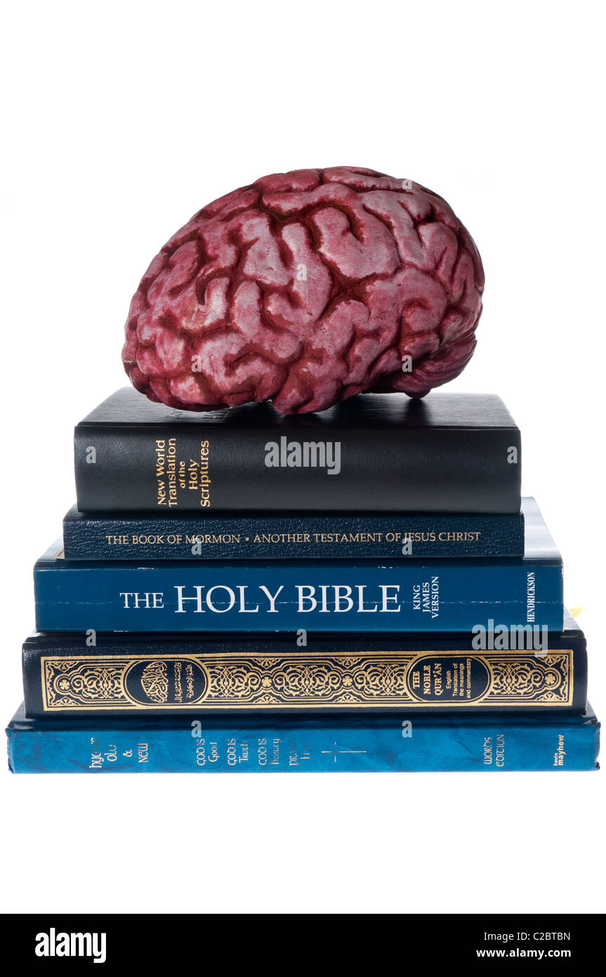 Model of a brain on top of various religious books and bibles. Stock Photo