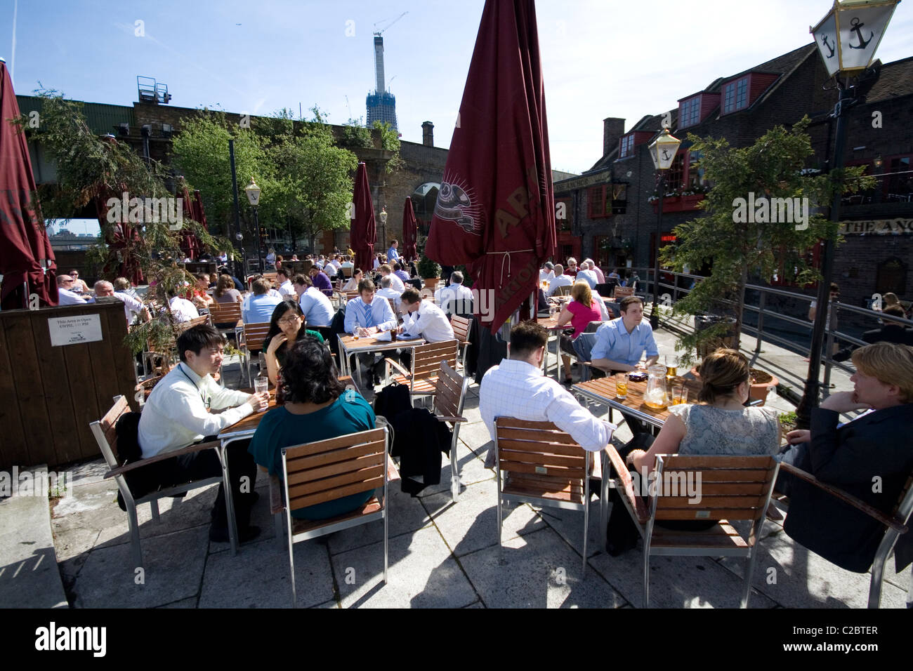 Office workers dining outside near the Anchor Pub on the south bank of the Thames in London. Stock Photo