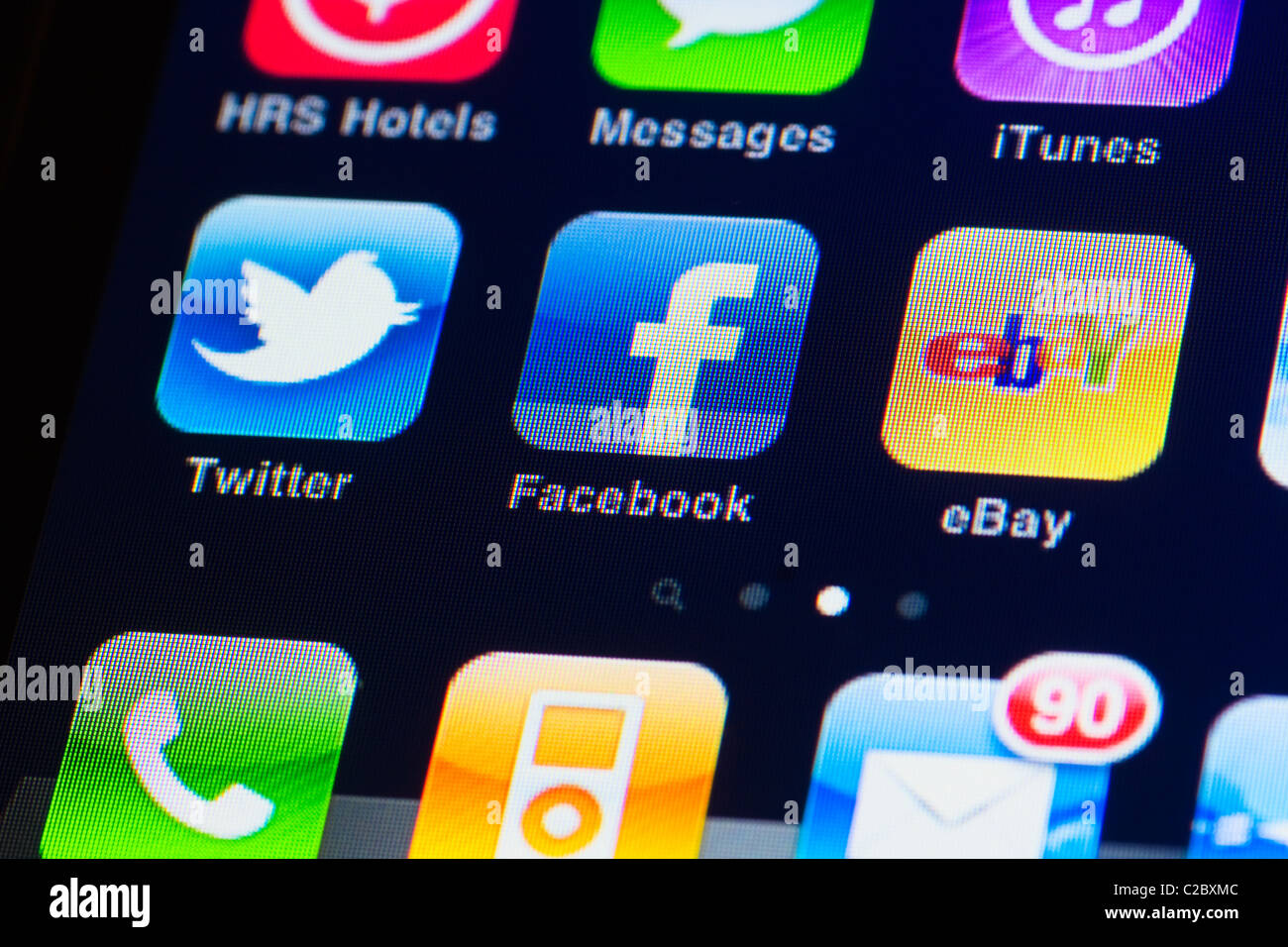 Detail macro image of the iphone touch screen. Display shows apps from facebook, twitter, ebay, itunes and messages Stock Photo
