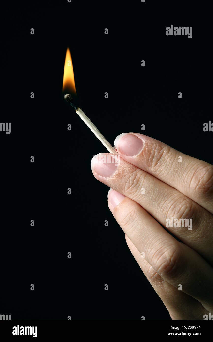 Hand holding a burning match Stock Photo Alamy