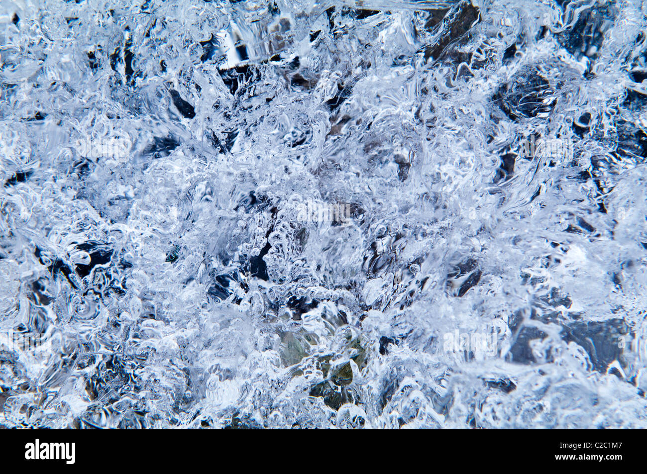 Mosaic patterns of air bubbles trapped in a block of transparent ice. Stock Photo