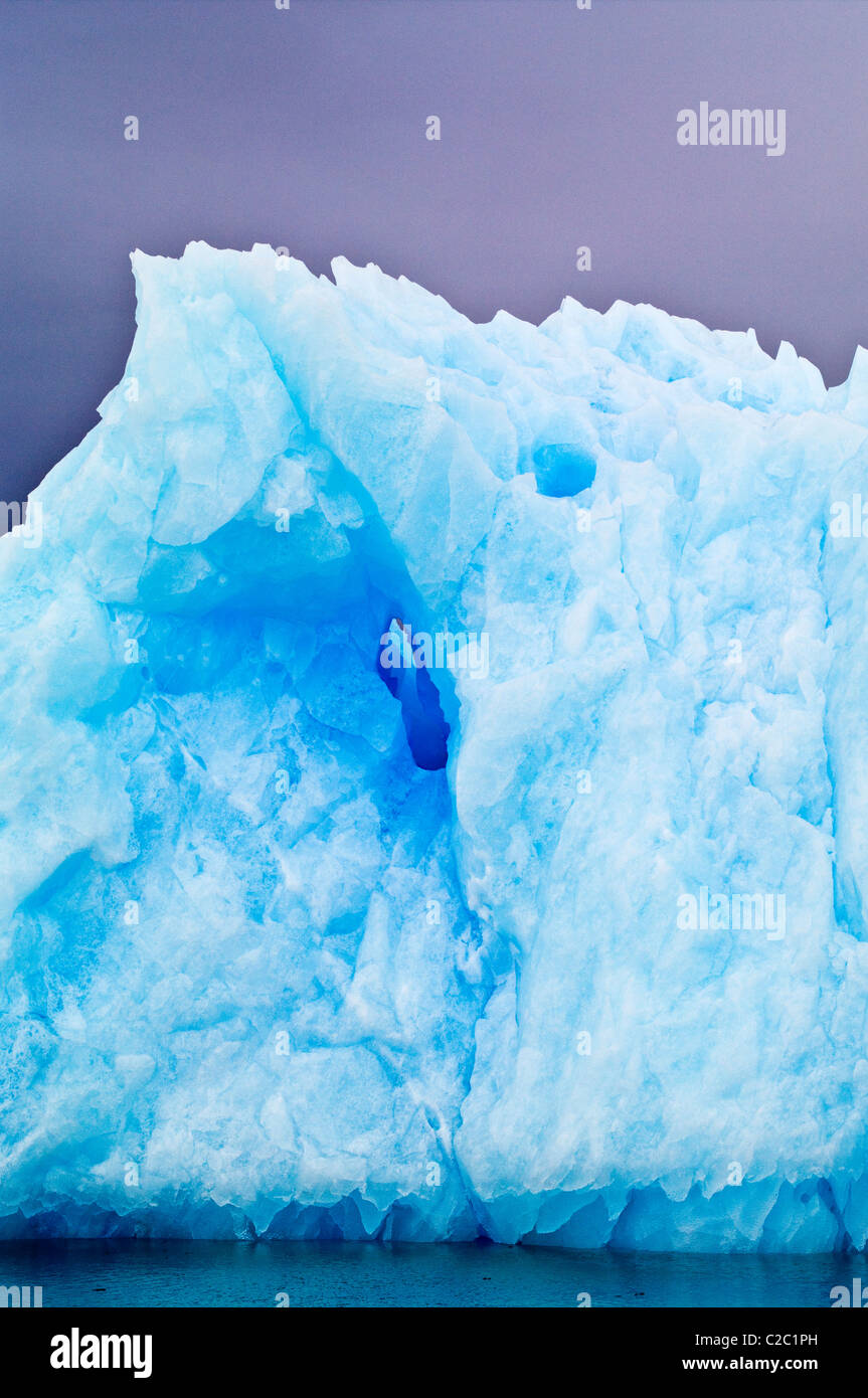 Razor serrations on the edge of an iridescent blue iceberg. Stock Photo