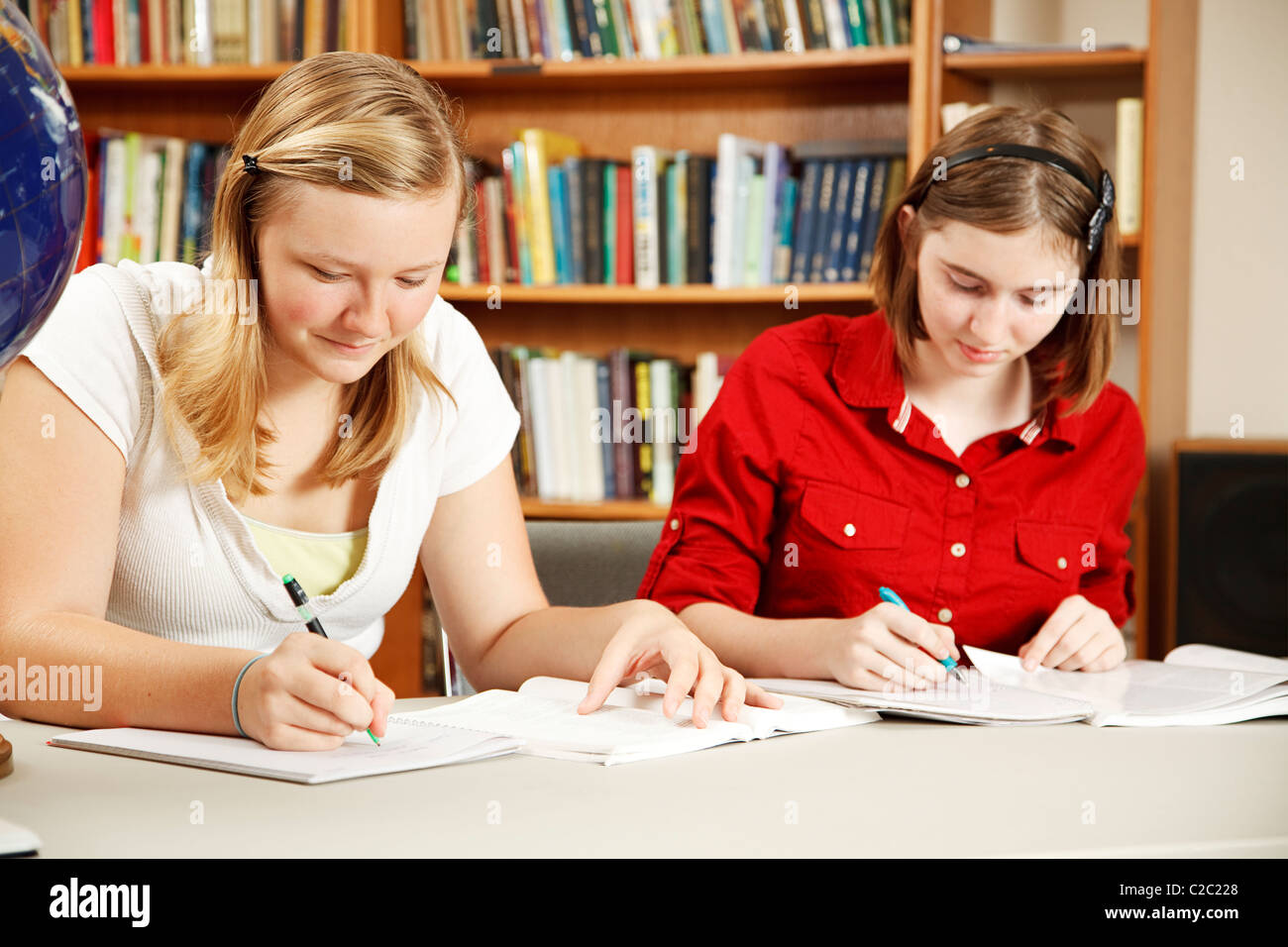 Two high school students doing their homework in the library Stock ...