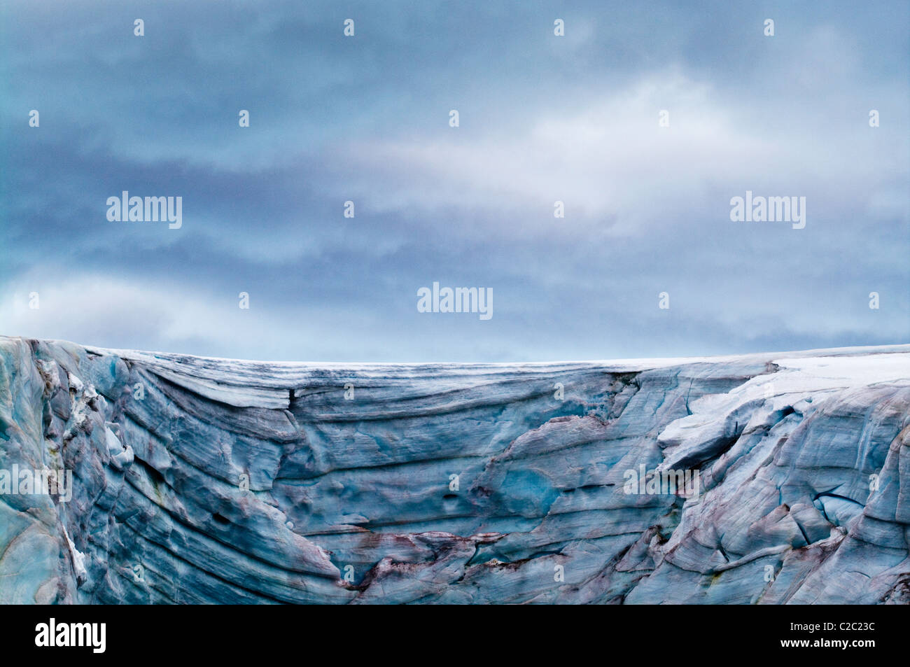 A rugged cold weathered glacier cap with pink Snow Algae, cryoalgae. Stock Photo