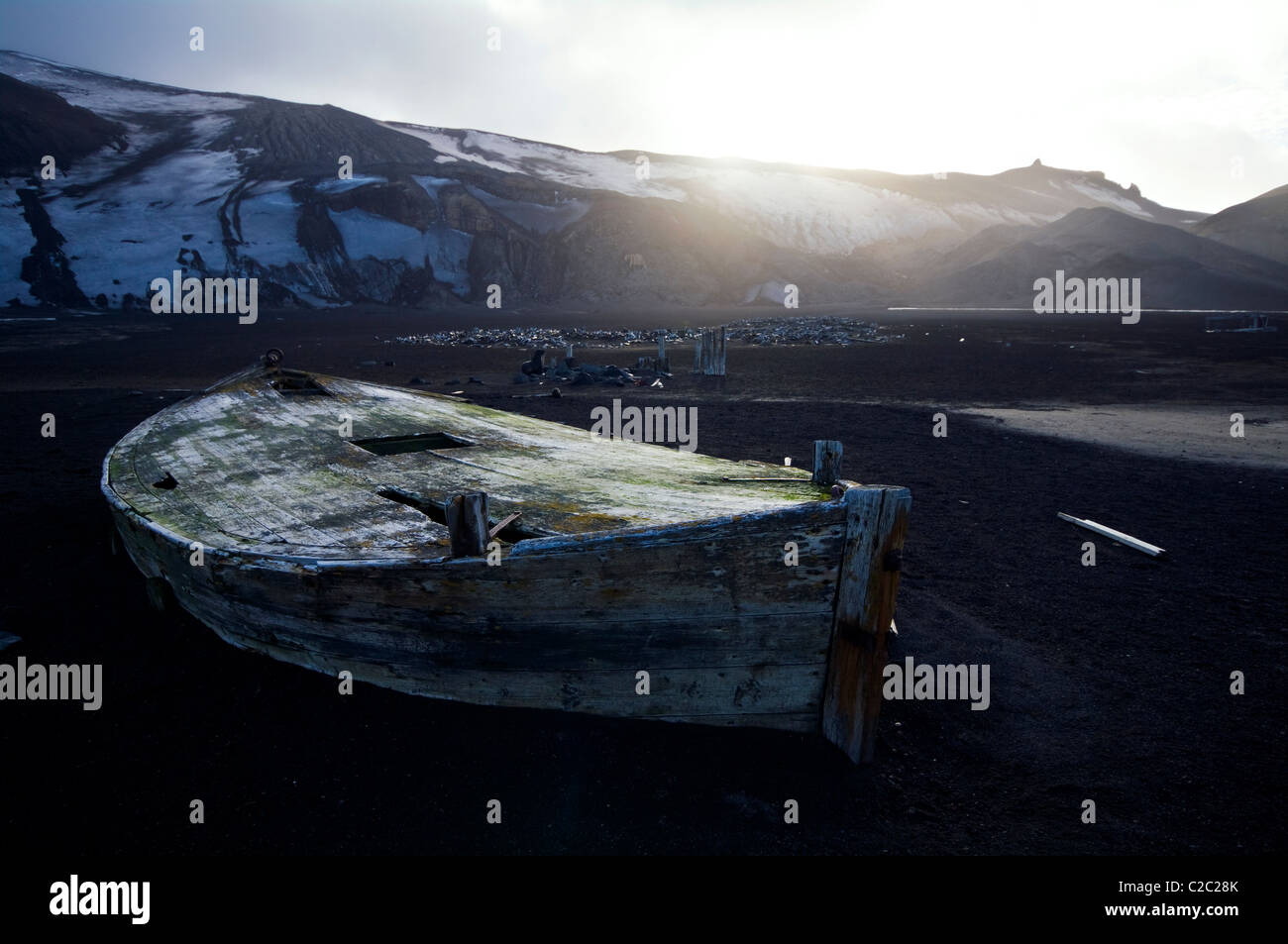 Antique timber whaling boat ruins stranded in black volcanic sand. Stock Photo