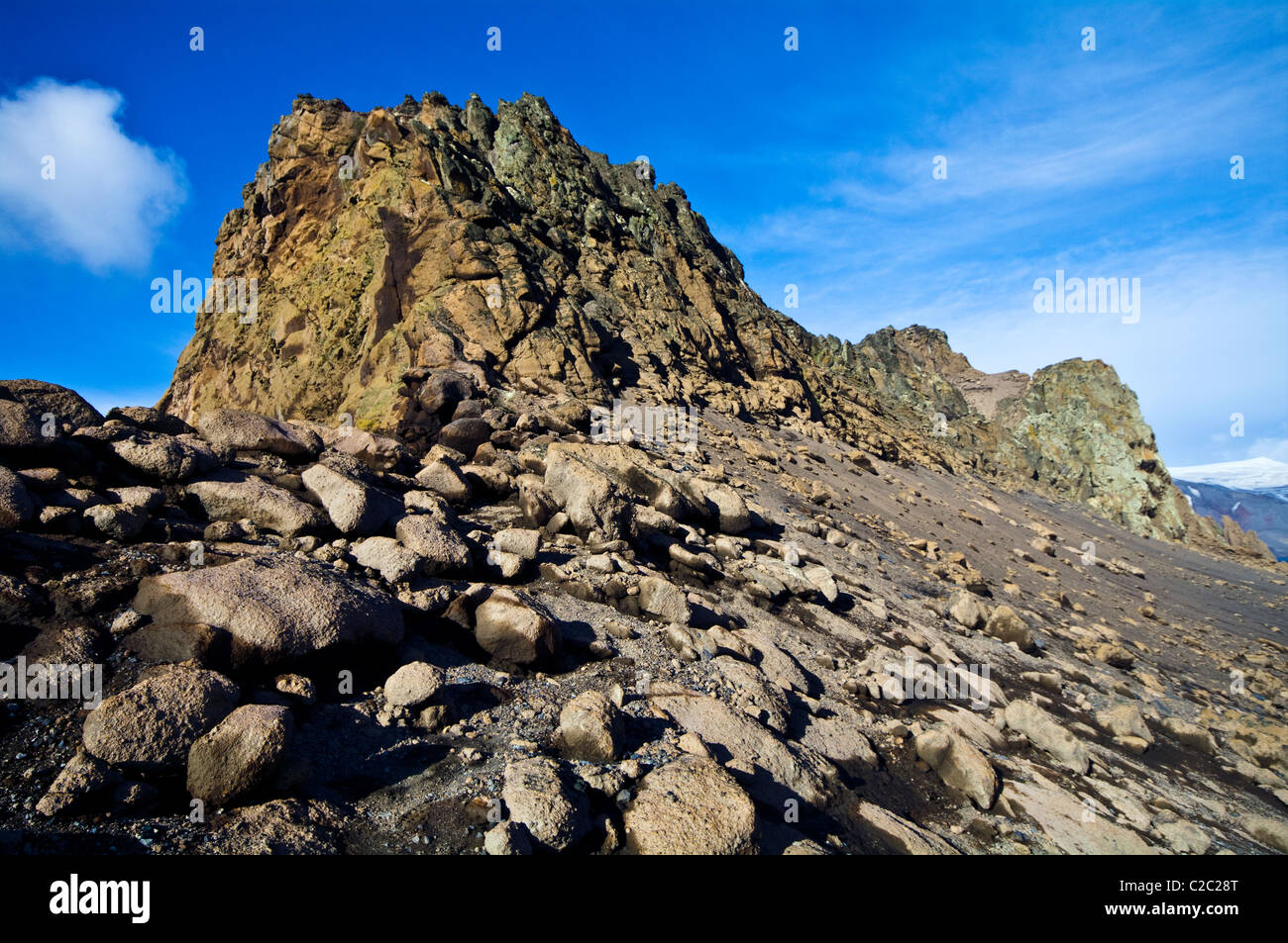 Boulders and black volcanic sand crowd the rim of an active volcano. Stock Photo