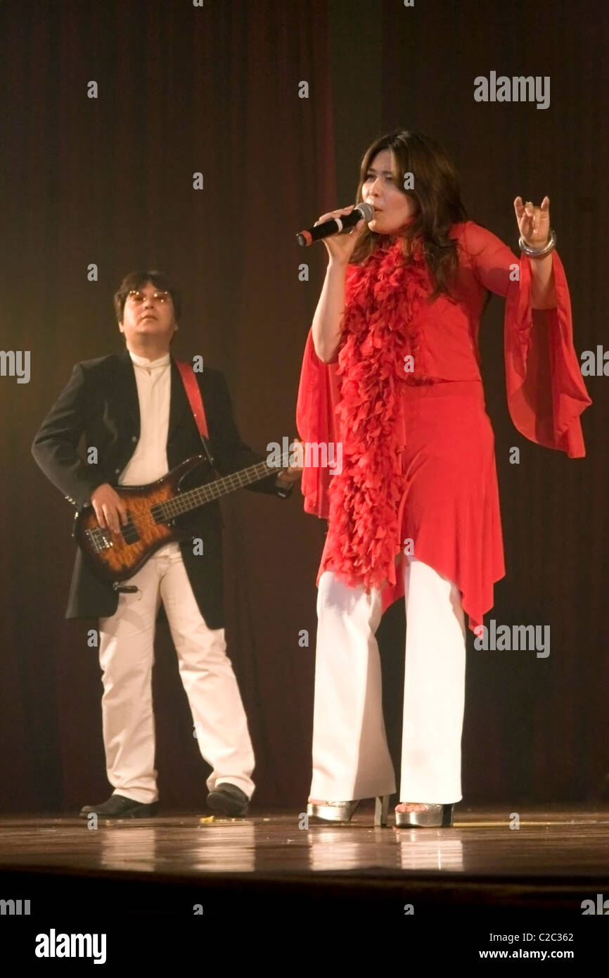 A woman singer a Japanese guitar player are performing for an audience