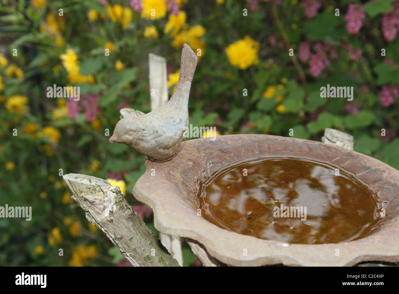 metal birdbath in garden Stock Photo