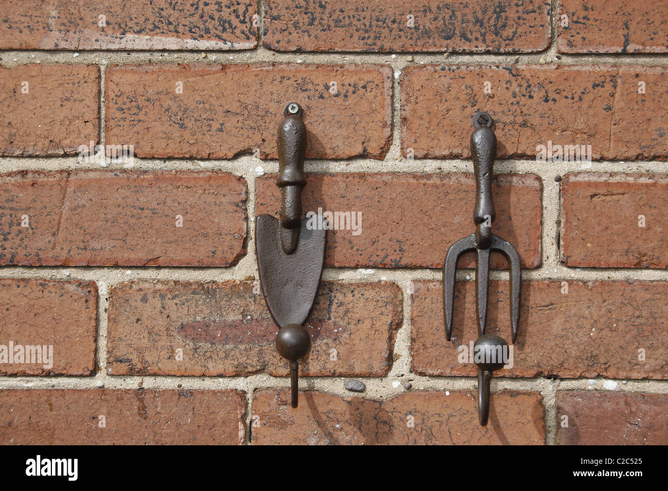 fork and trowel ornaments hanging on wall Stock Photo