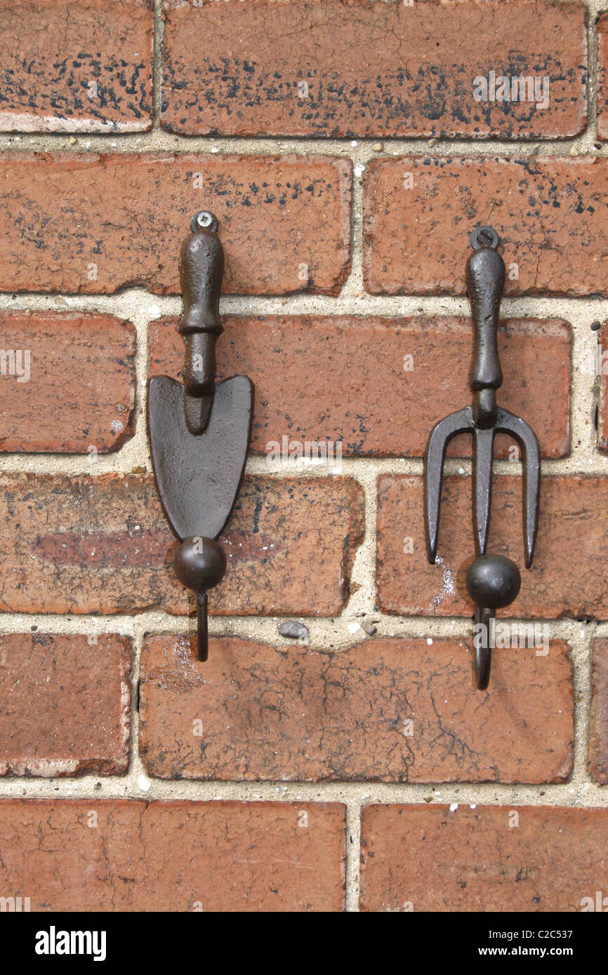 fork and trowel ornaments hanging on wall Stock Photo