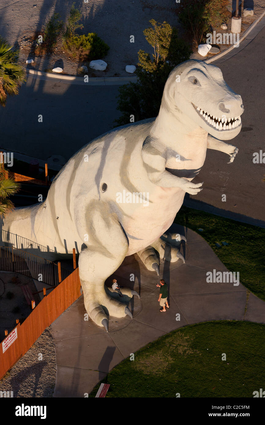 AERIAL VIEW. A monumental tyrannosaur as a roadside attraction alongside interstate 10. Cabazon, Riverside County, California, USA. Stock Photo