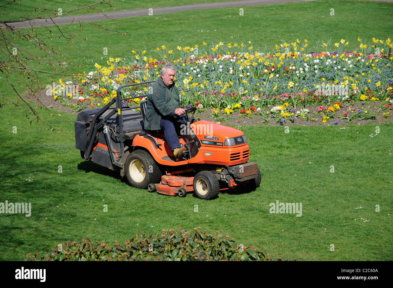 Ride on mower with operative cutting grass in a public park. Newbury