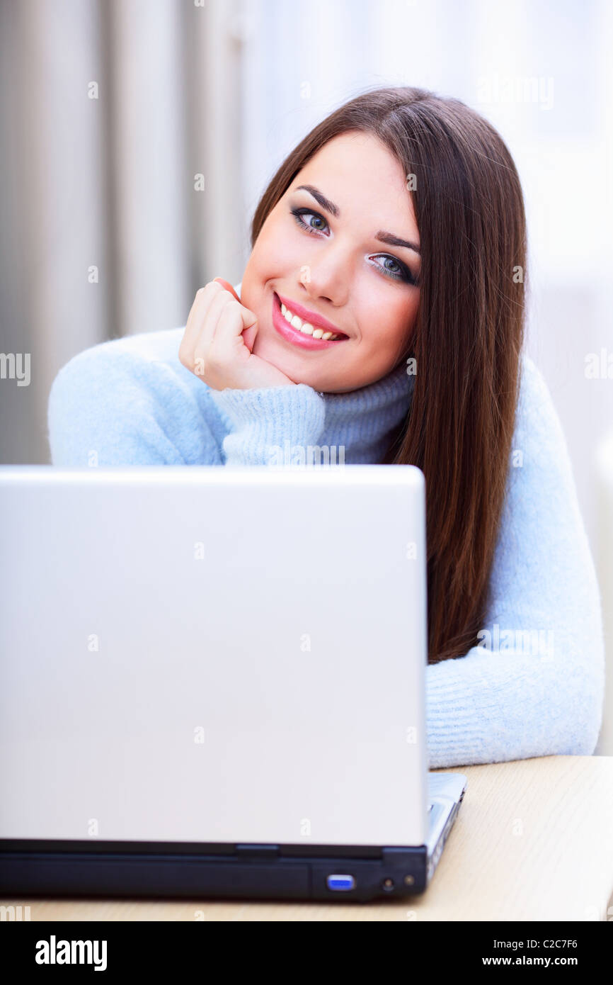 Happy young woman using laptop at home Stock Photo - Alamy