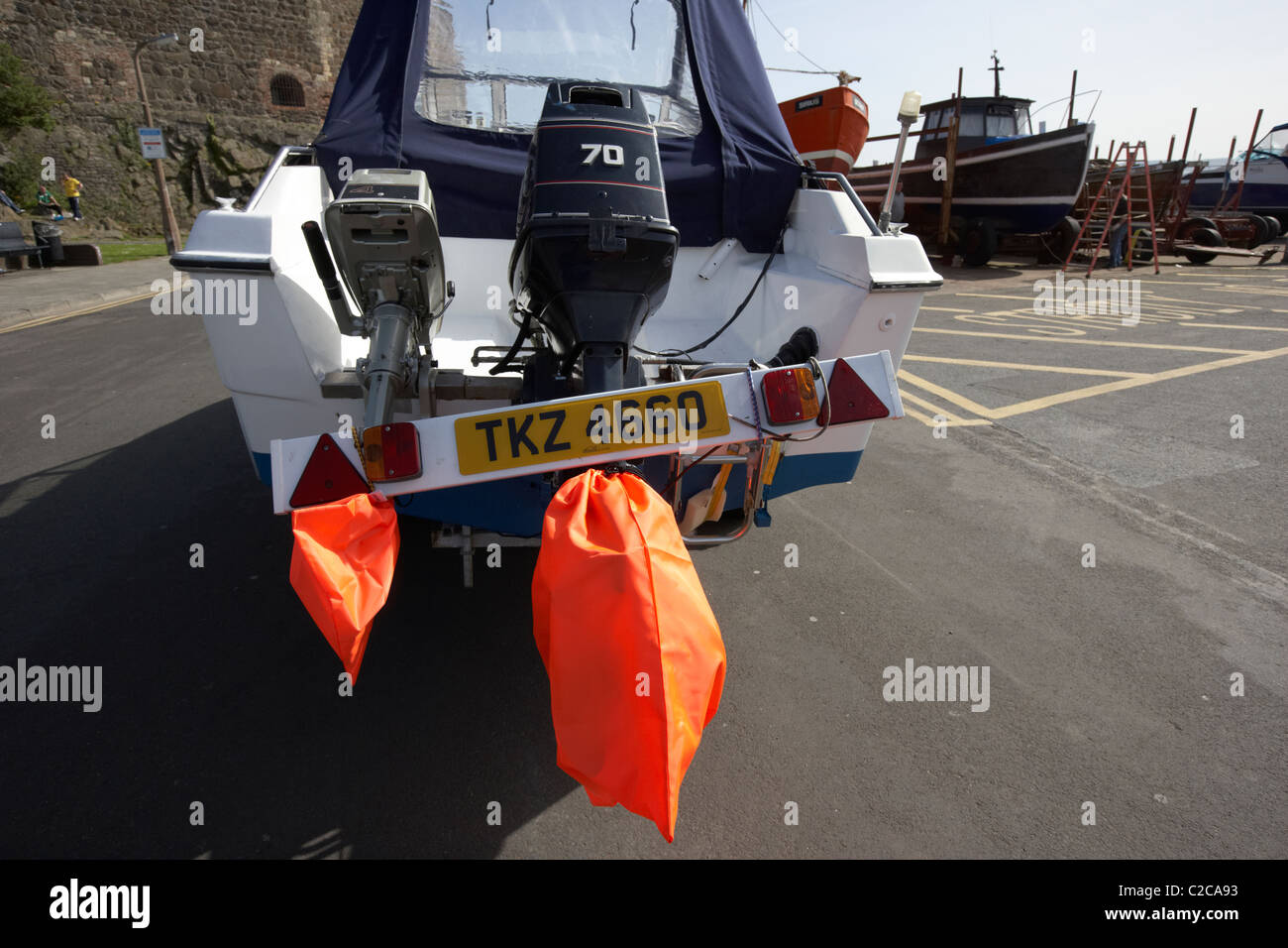 outboard engines trailer light board and high visibility prop covers on a boat being towed in the uk Stock Photo