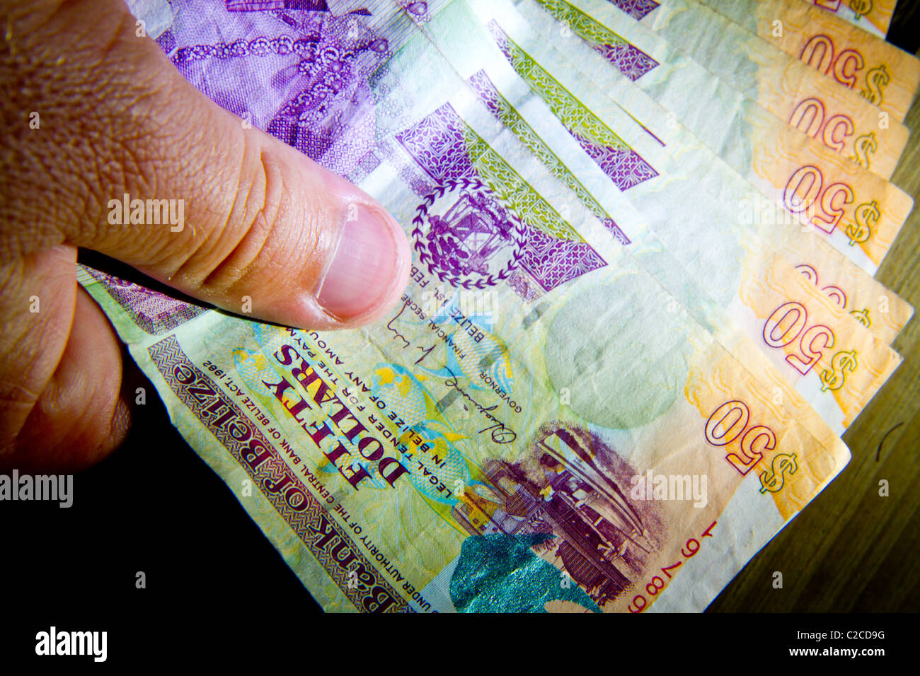 A hand full of cash from Belize. Stock Photo