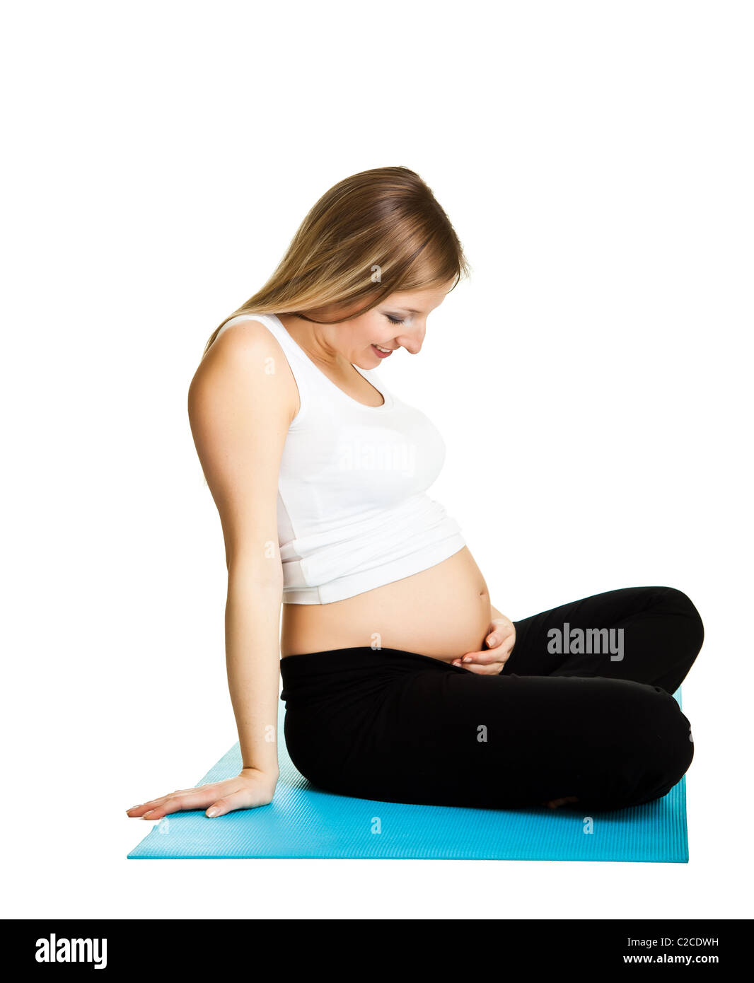 Caucasian blond 6th month pregnant young adult woman excercises fitness