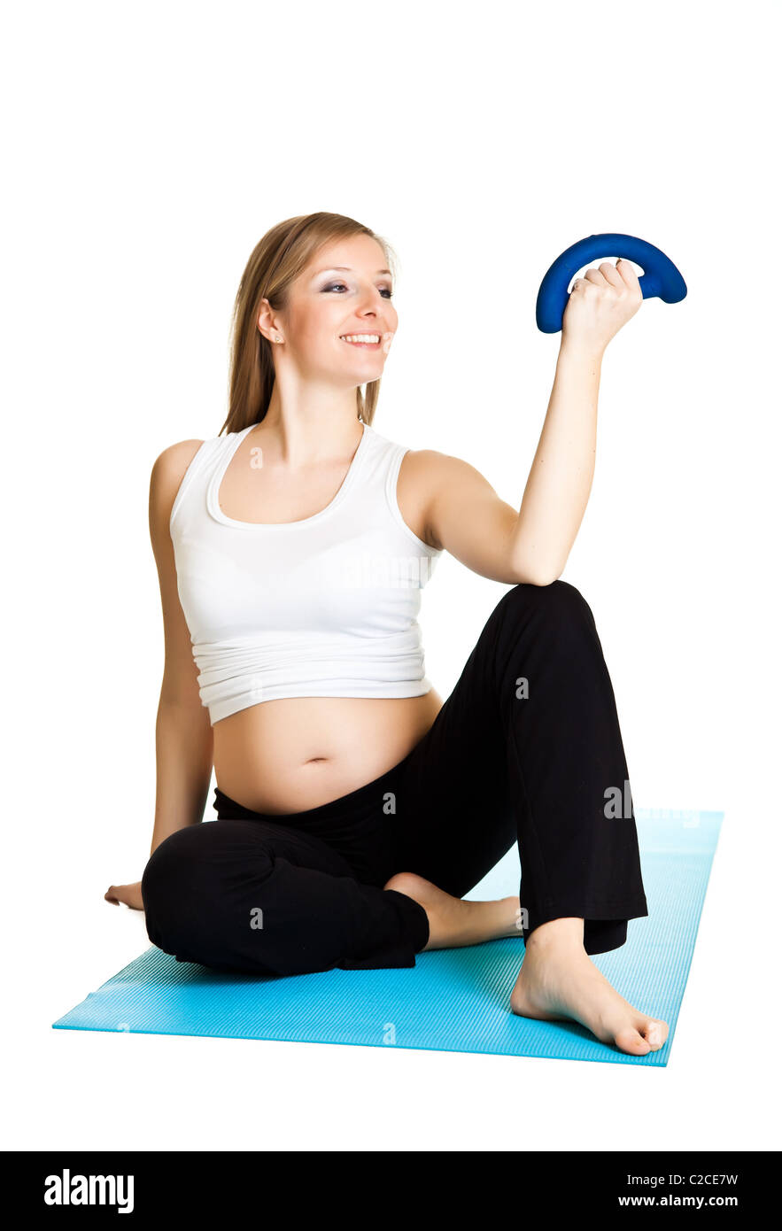 Caucasian blond 6th month pregnant young adult woman excercises fitness