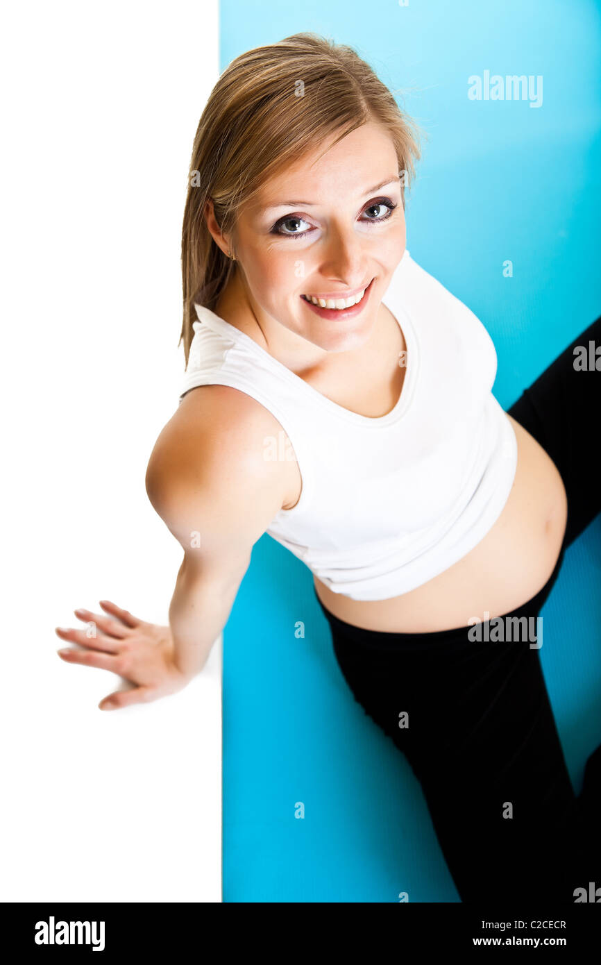 Caucasian blond 6th month pregnant young adult woman excercises fitness