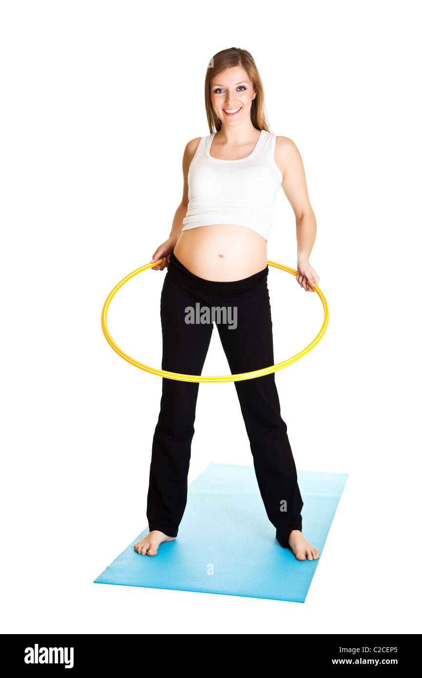 Caucasian blond 6th month pregnant young adult woman excercises fitness