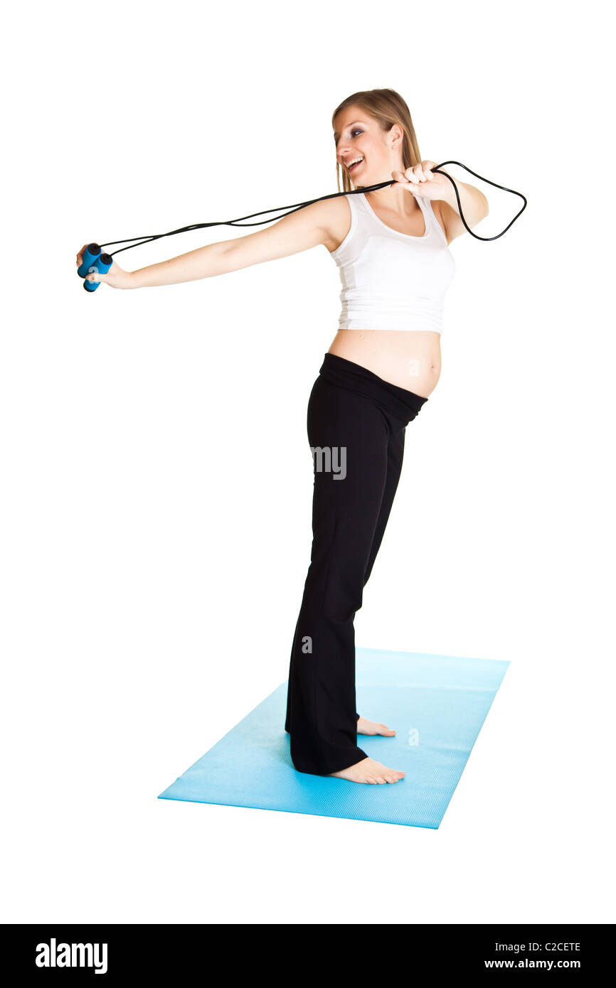 Caucasian blond 6th month pregnant young adult woman excercises fitness