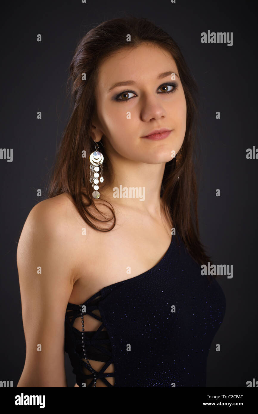 Portrait of a young woman in blue dress on dark background Stock Photo ...