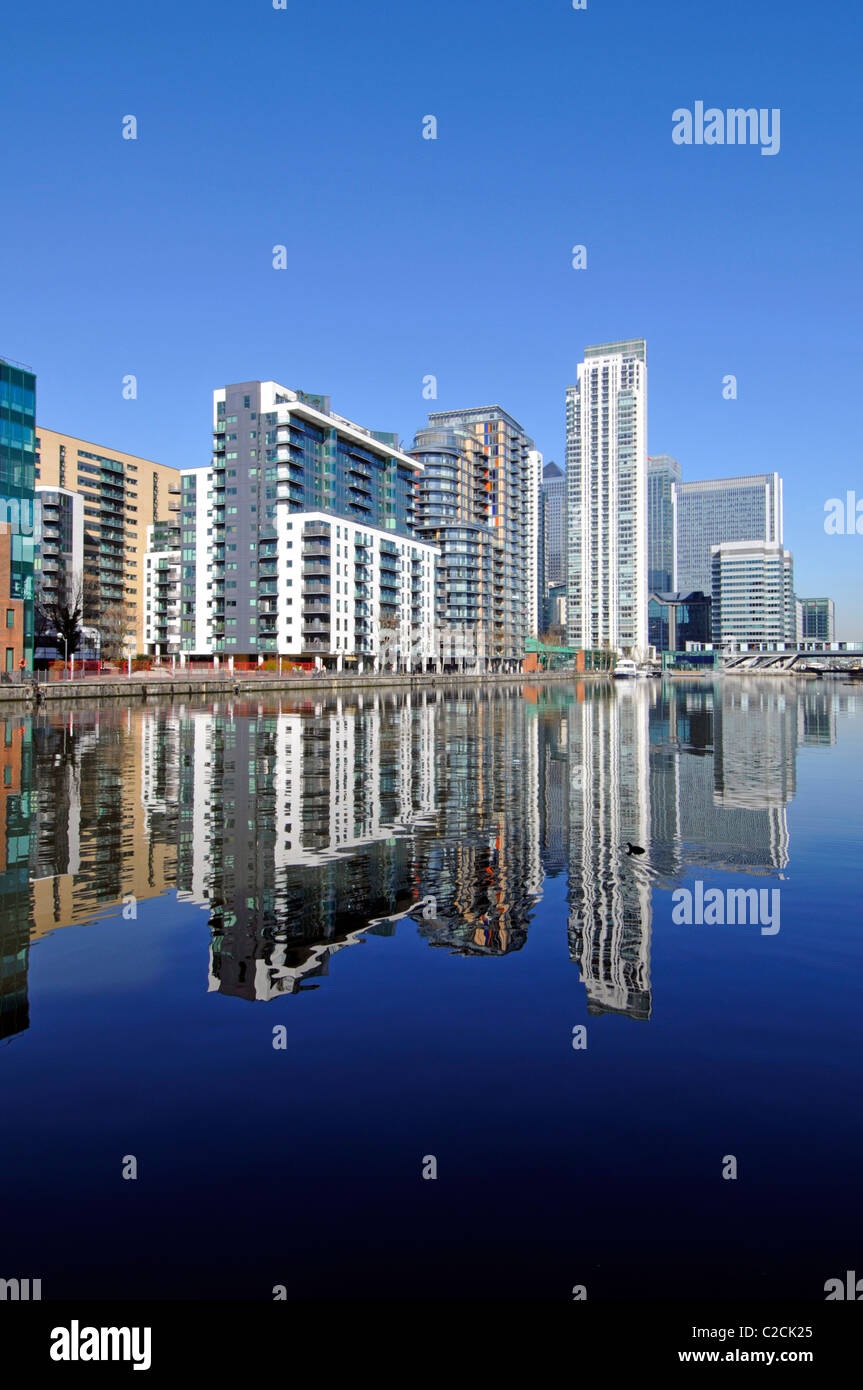 East London Docklands waterside high rise apartment flats development reflections Millwall Docks Canary Wharf Citi bank office tower block beyond UK Stock Photo