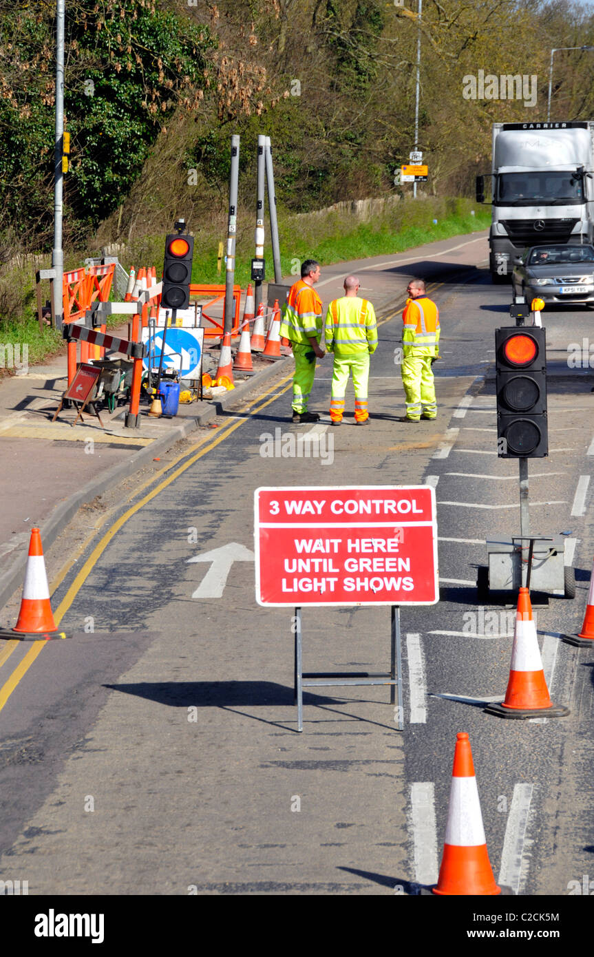 Workmen at road works and temporary traffic lights Stock Photo