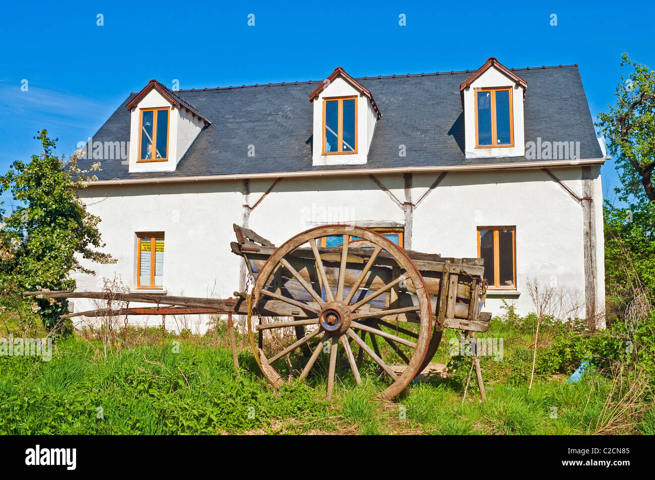 Old wooden farm cart in garden of renovated house - France. Stock Photo