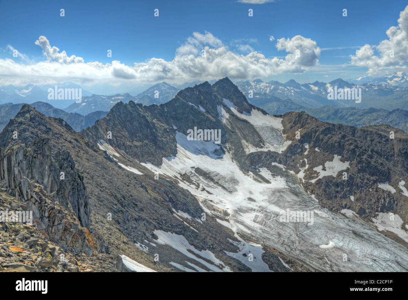 high alpine rocky sharp ridge with some ice and snow in summer Stock