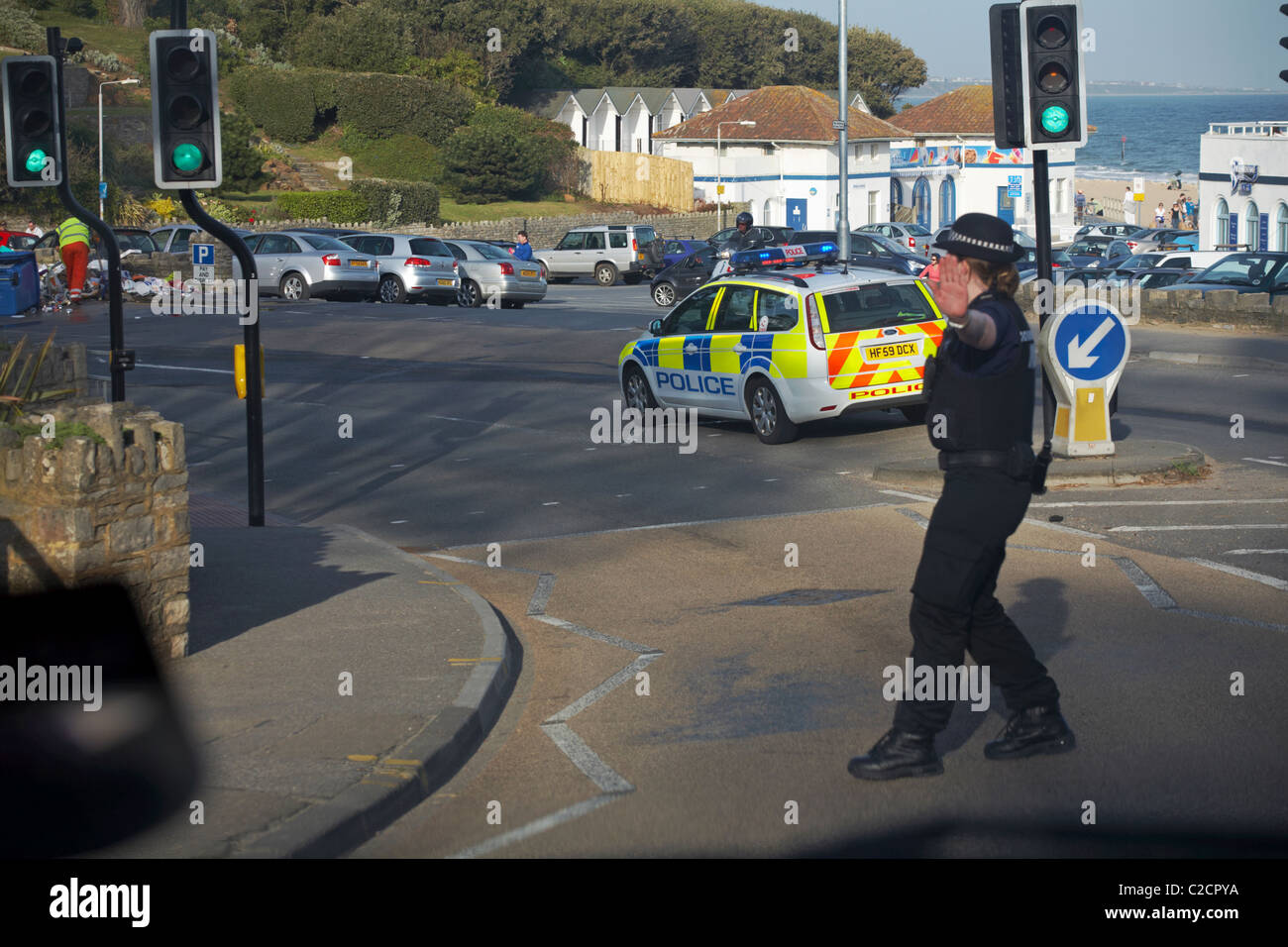 Police woman stopped car due to incident with rubbish strewn across pavement and road being cleared up at Branksome Chine, April Stock Photo