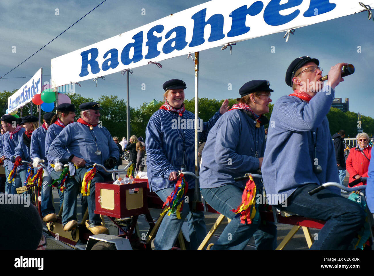 A group of people ride a multi-seat bicycle during the Freimarkt parade - Bremen, Germany Stock Photo