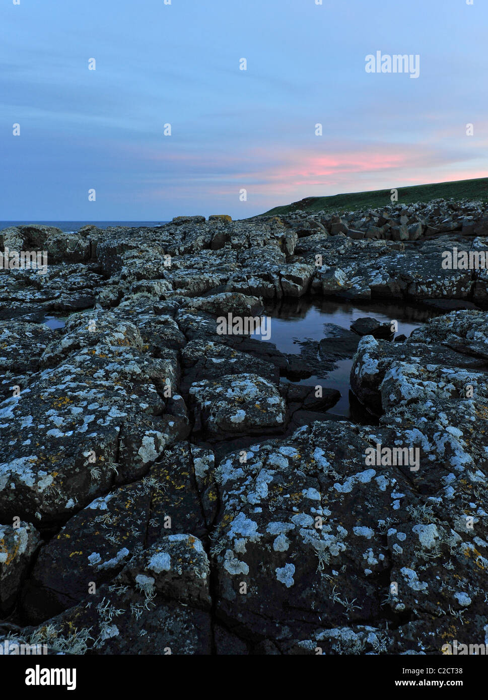 Seashore rocks at sunset. Stock Photo