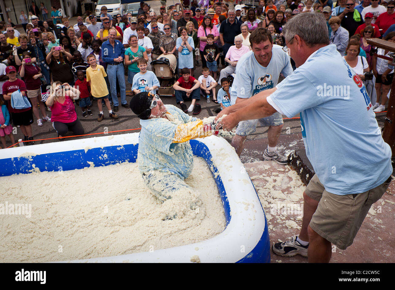A participant in the Grits Roll wallows in a pool of grits during the