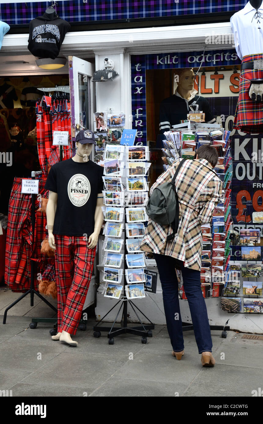 A customer browses outside an souvenir shop in Edinburgh while a tartan trousered mannequin looks on. Stock Photo